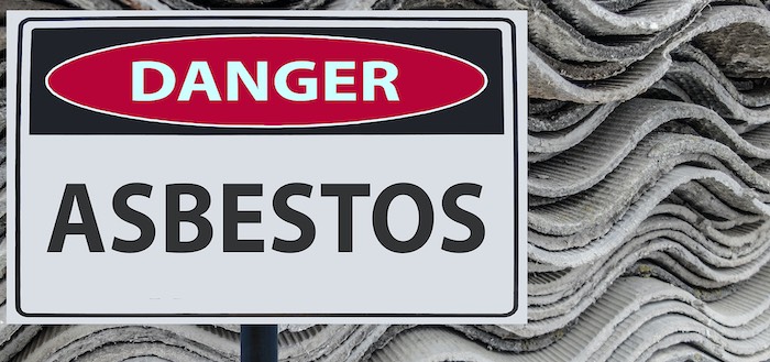 Asbestos sign against backdrop of asbestos sheets